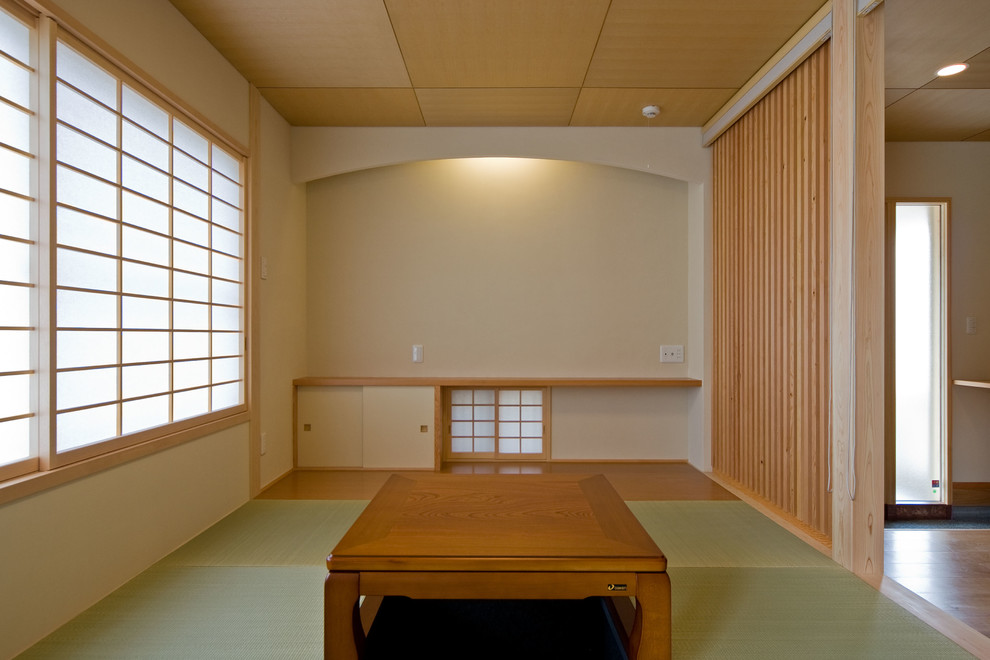 Modelo de sala de estar de estilo zen con paredes beige, tatami y suelo verde