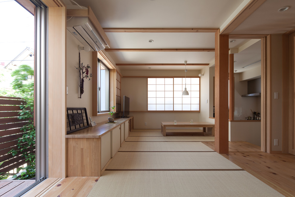Modelo de sala de estar de estilo zen con paredes blancas, tatami, televisor independiente y suelo verde