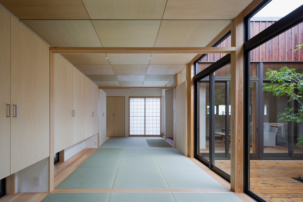 Abgetrenntes Asiatisches Wohnzimmer mit weißer Wandfarbe, Tatami-Boden und grünem Boden in Osaka