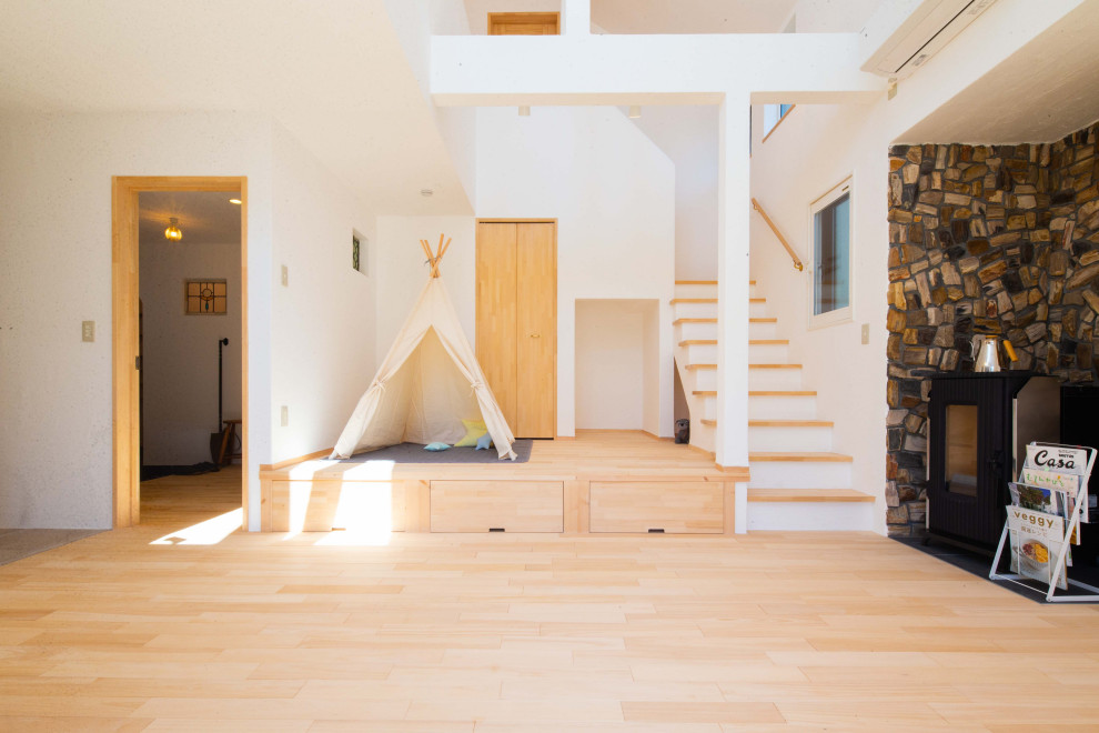 Foto de sala de estar abierta de estilo americano de tamaño medio con paredes blancas, suelo de madera clara, chimenea de esquina y marco de chimenea de piedra