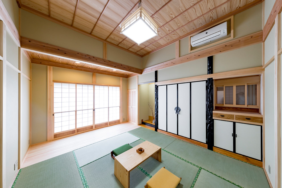 Cette image montre une salle de séjour asiatique fermée avec un mur vert, un sol de tatami et un sol vert.