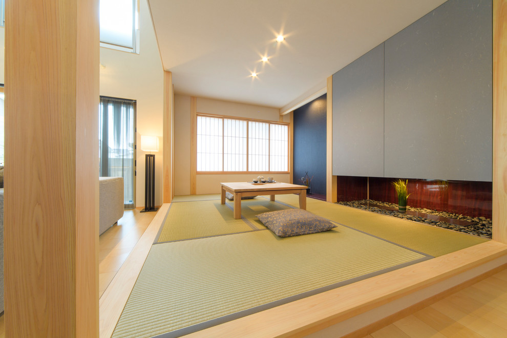Aménagement d'une petite salle de séjour asiatique ouverte avec un mur blanc, un sol de tatami et un sol vert.