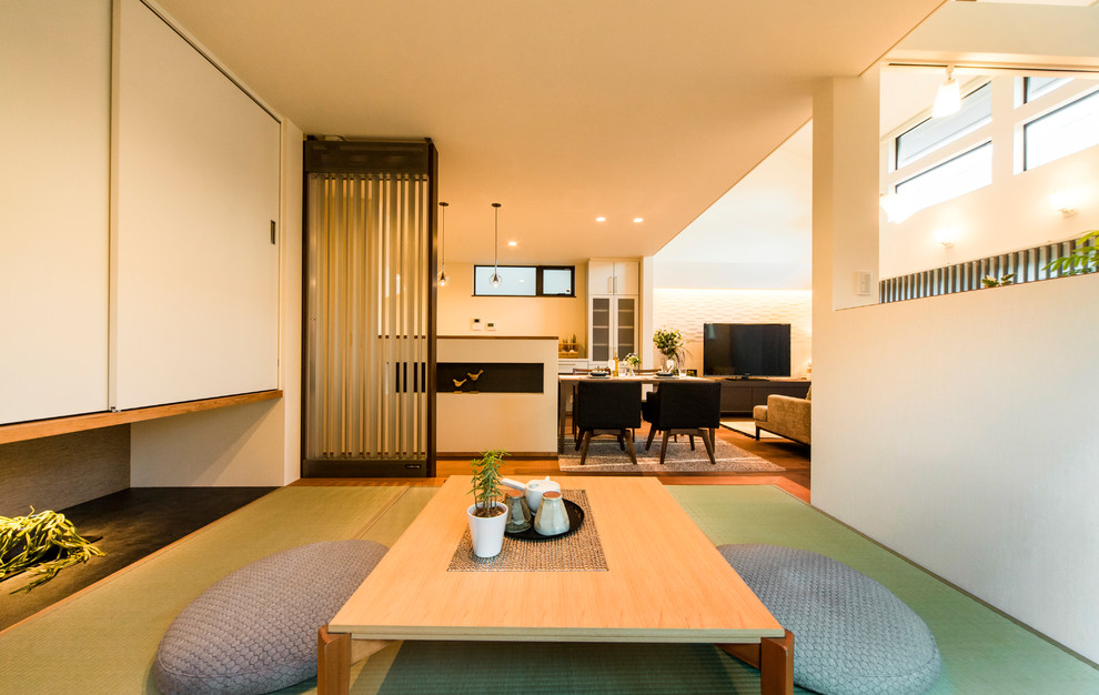 Стильный дизайн: открытая гостиная комната в восточном стиле с белыми стенами, татами и зеленым полом - последний тренд