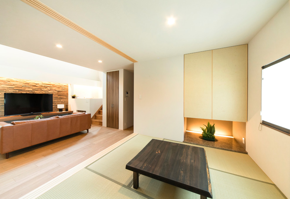 Example of an open concept tatami floor and green floor family room design in Other with white walls and a tv stand