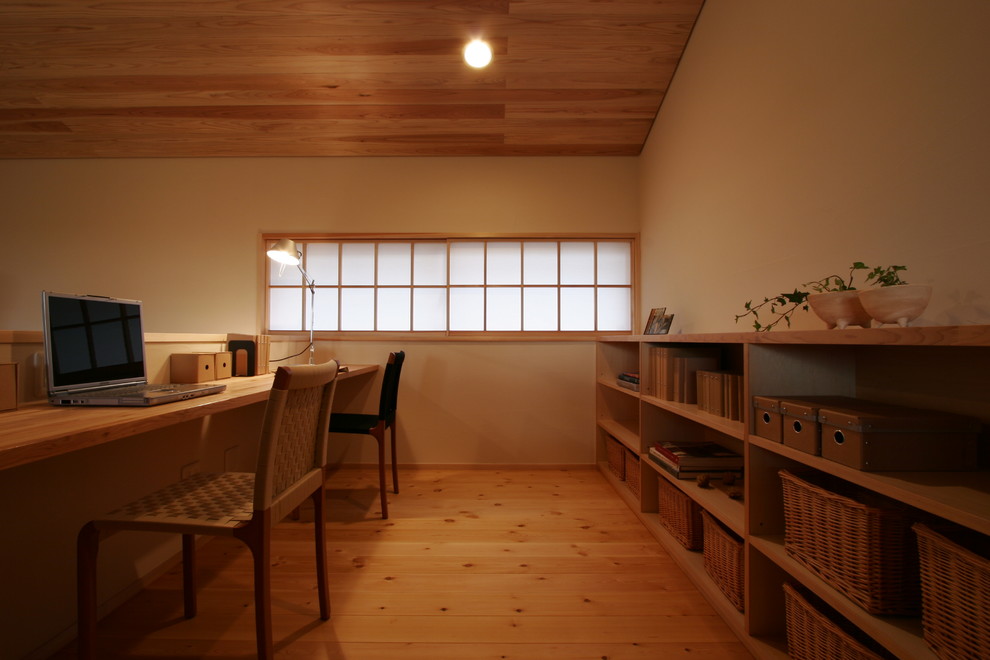 Modelo de sala de estar con biblioteca minimalista con paredes beige, suelo de madera en tonos medios y suelo beige