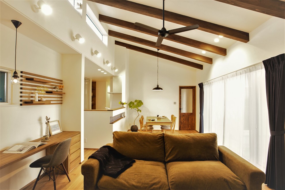 Cette image montre une salle de séjour design ouverte avec un mur blanc, un sol en bois brun et un sol marron.