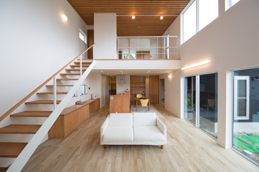 Foto di un soggiorno etnico con pareti bianche, pavimento in legno verniciato e pavimento marrone