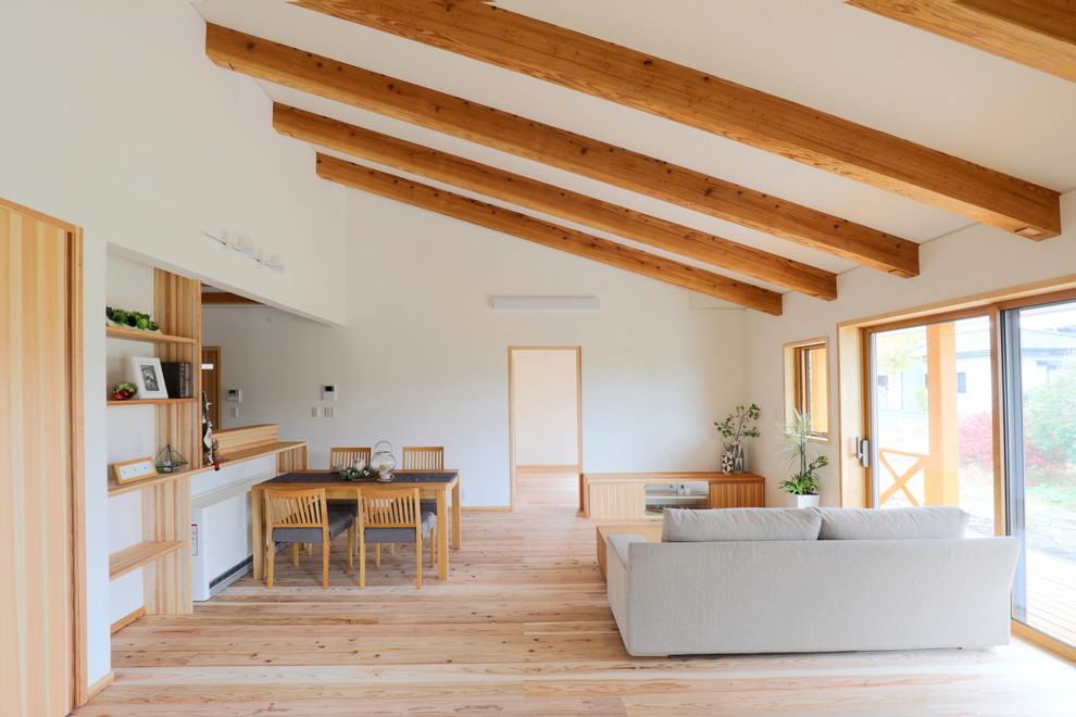 Idee per un soggiorno minimalista con pareti bianche, parquet chiaro e pavimento beige