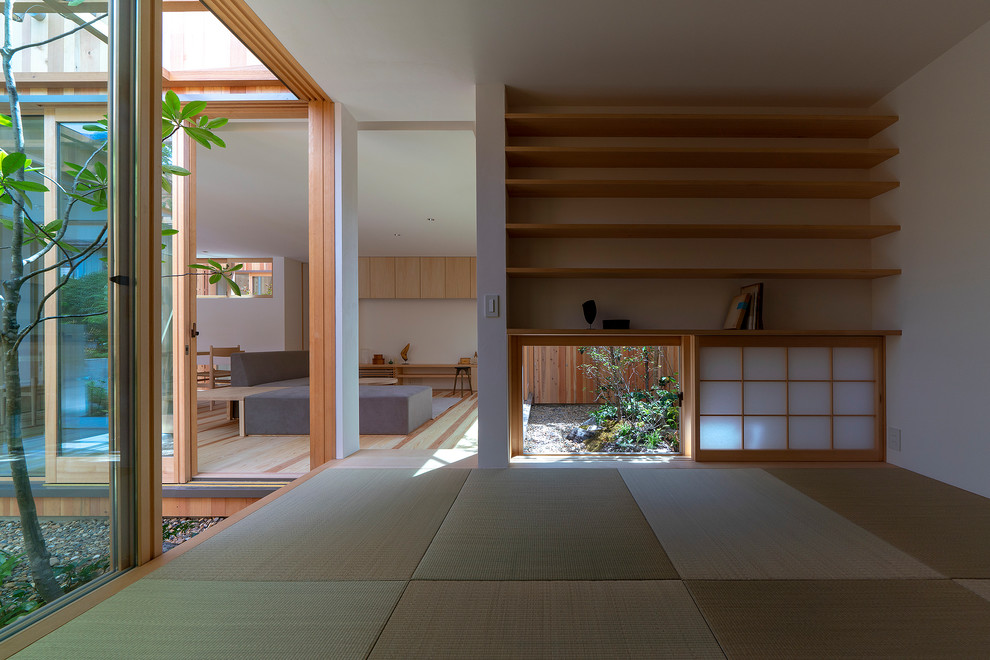 Пример оригинального дизайна: маленькая изолированная гостиная комната с белыми стенами, зеленым полом и татами без камина, телевизора для на участке и в саду