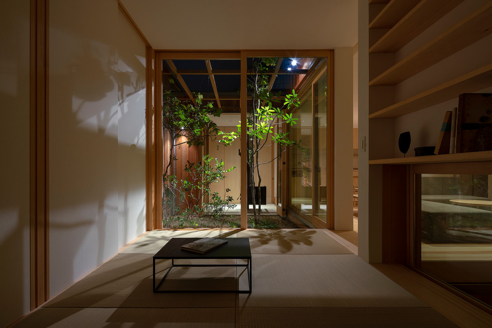 Cette photo montre une salle de séjour asiatique avec un mur blanc, un sol de tatami et aucun téléviseur.