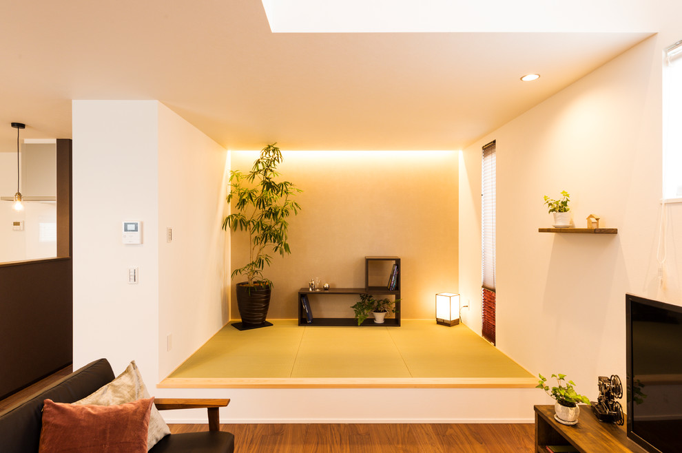 Esempio di un soggiorno etnico con pareti bianche, pavimento in tatami, TV autoportante e pavimento verde
