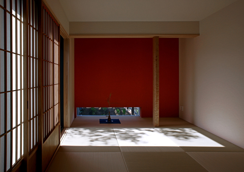 東京23区にある中くらいな和風のおしゃれな独立型ファミリールーム (赤い壁) の写真