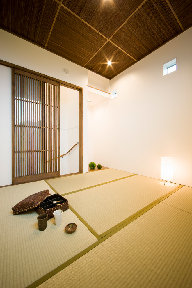 Aménagement d'une salle de séjour contemporaine avec un mur blanc, un sol de tatami et un sol beige.
