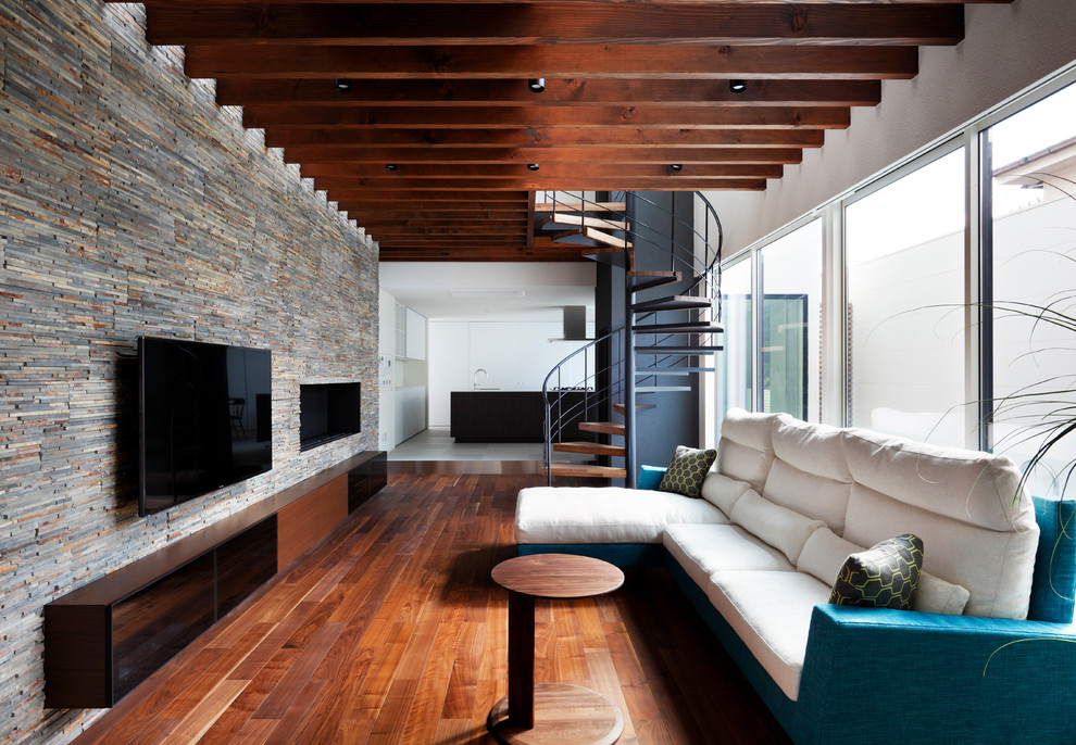 Foto de sala de estar abierta contemporánea con suelo de madera oscura, chimenea lineal, marco de chimenea de piedra, televisor colgado en la pared, paredes multicolor y suelo marrón