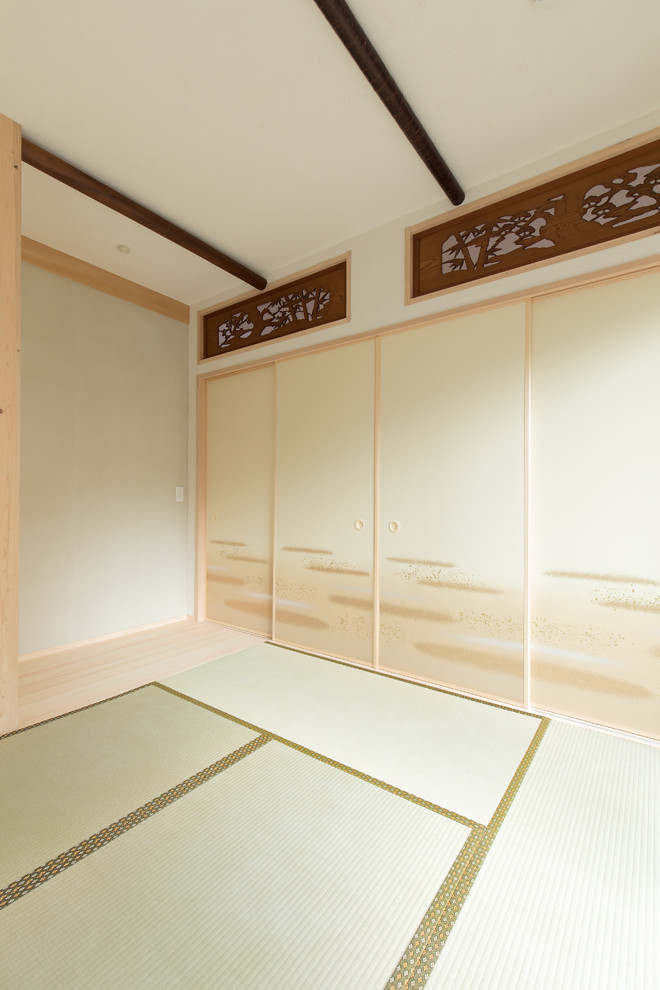 Ejemplo de sala de estar cerrada asiática con paredes blancas, tatami y suelo verde