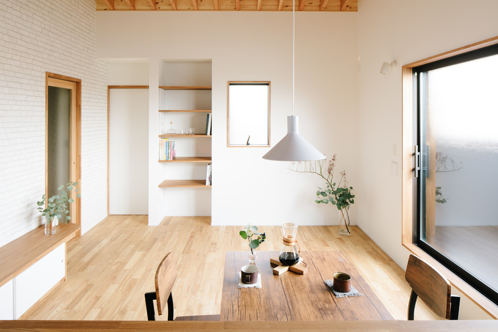 Réalisation d'une petite salle de séjour nordique ouverte avec un mur blanc, un sol en bois brun, un téléviseur indépendant et un sol marron.