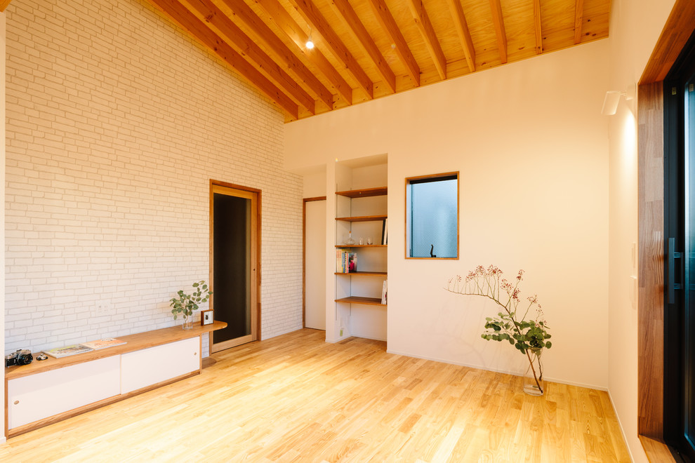 На фото: маленькая открытая гостиная комната в скандинавском стиле с белыми стенами, паркетным полом среднего тона, отдельно стоящим телевизором и коричневым полом для на участке и в саду