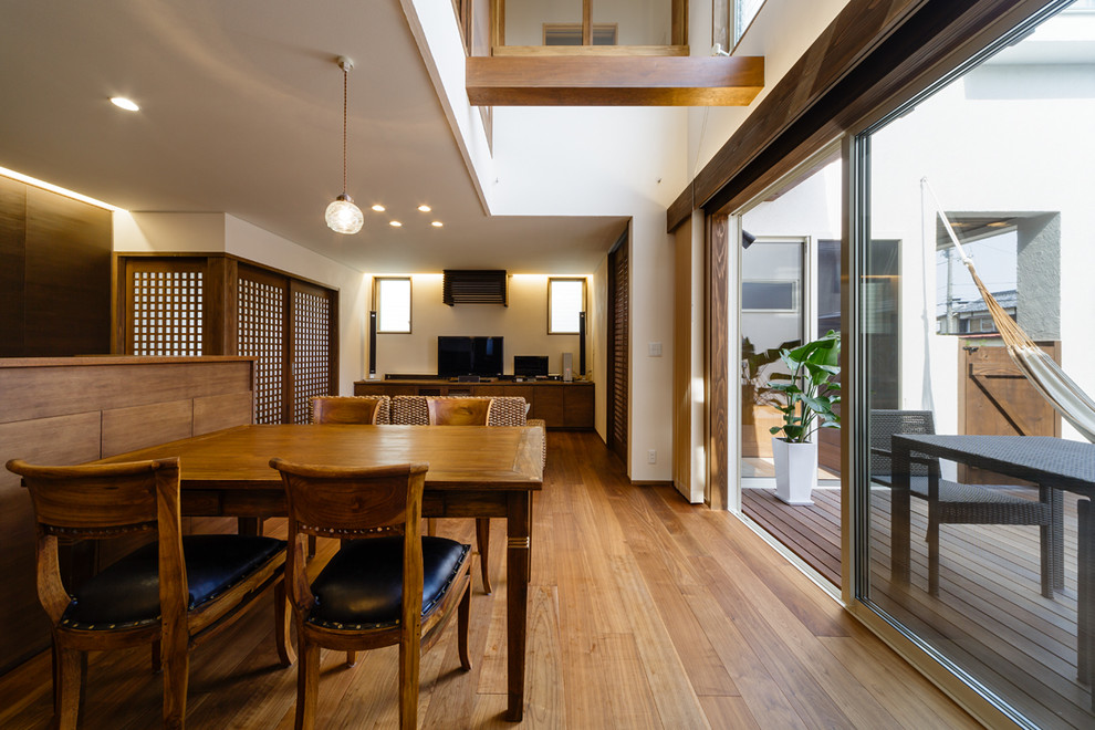 Immagine di un soggiorno etnico aperto con pareti bianche, pavimento in legno massello medio e pavimento marrone