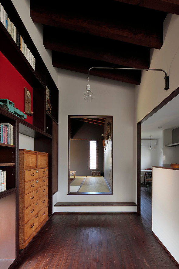 Mittelgroßes, Offenes Mid-Century Wohnzimmer ohne Kamin mit weißer Wandfarbe, dunklem Holzboden, freistehendem TV und braunem Boden in Sonstige
