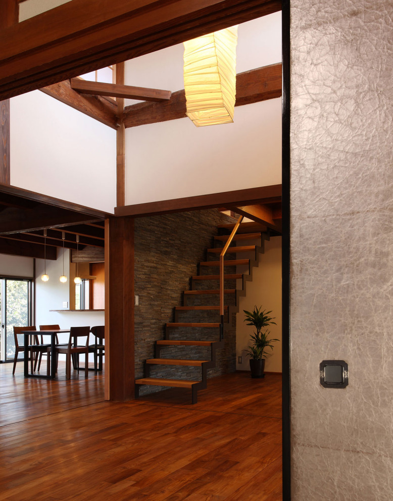Idée de décoration pour une salle de séjour asiatique de taille moyenne avec un mur blanc, parquet foncé et un sol marron.