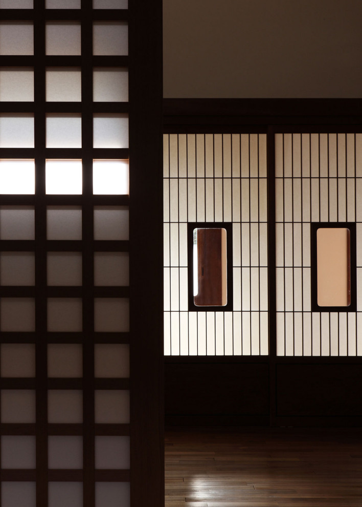 Cette image montre une salle de séjour asiatique de taille moyenne avec un mur blanc, parquet foncé et un sol marron.