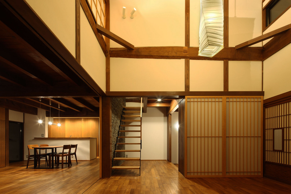 Aménagement d'une salle de séjour asiatique de taille moyenne avec un mur blanc, parquet foncé et un sol marron.