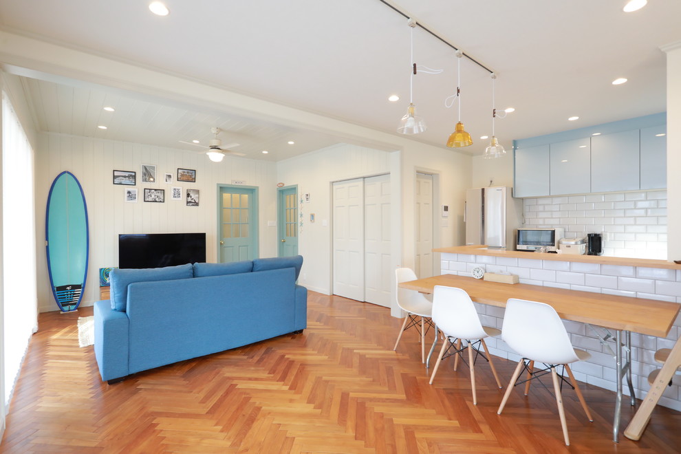 Maritimes Wohnzimmer mit weißer Wandfarbe, braunem Holzboden und braunem Boden in Sonstige