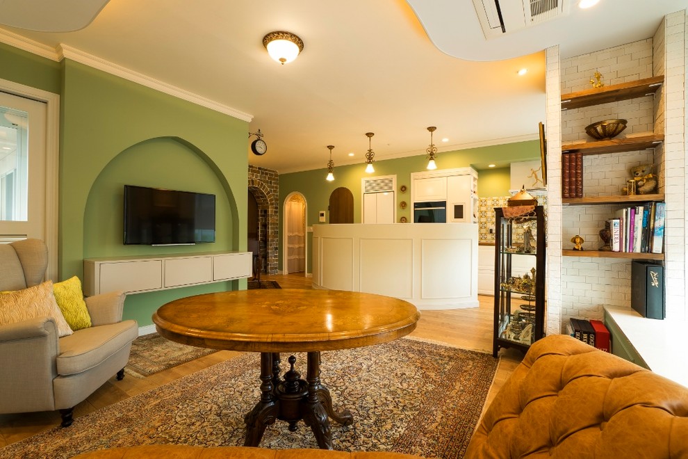Inspiration pour une salle de séjour traditionnelle ouverte avec un mur vert, parquet clair, un téléviseur fixé au mur et un sol marron.