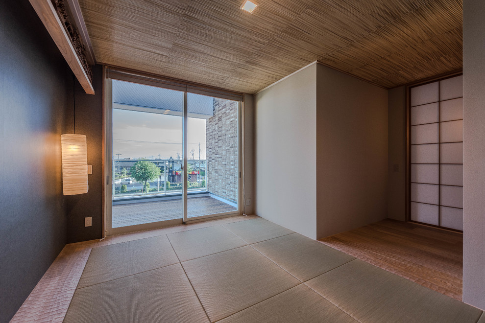 Immagine di un soggiorno etnico con pareti nere, pavimento in tatami, nessun camino e nessuna TV