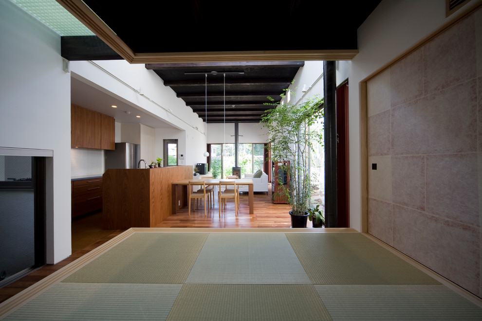 Cette photo montre une salle de séjour asiatique ouverte avec un mur blanc, parquet foncé, un poêle à bois, un manteau de cheminée en pierre, un téléviseur indépendant et un sol marron.