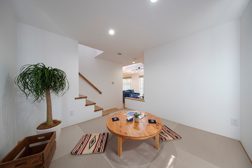 Exemple d'une salle de séjour tendance avec un mur blanc, un sol de tatami et un sol gris.