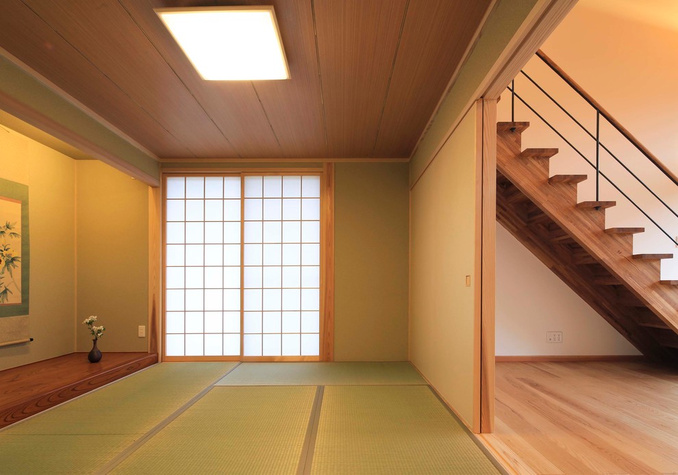 Aménagement d'une salle de séjour asiatique avec un mur vert, un sol de tatami et un sol vert.