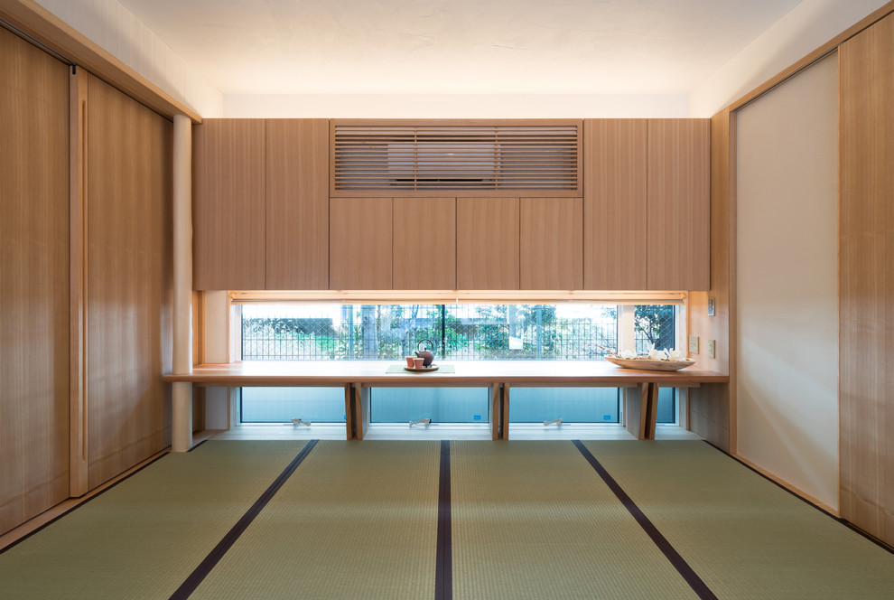 Imagen de sala de estar asiática con paredes blancas, tatami y suelo verde