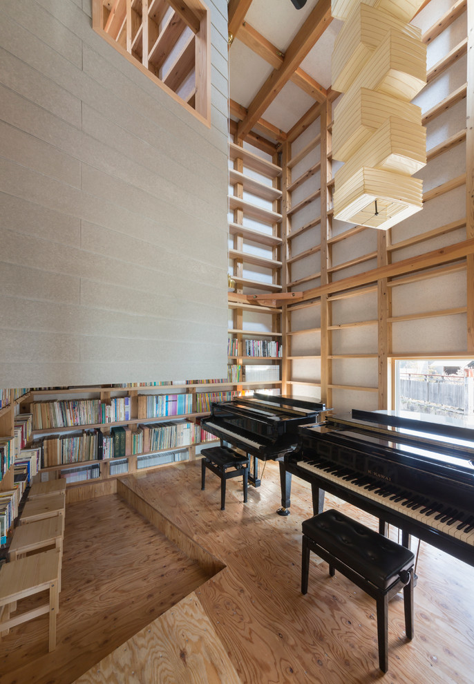 Aménagement d'une salle de séjour contemporaine avec une salle de musique, un mur blanc et un sol en bois brun.
