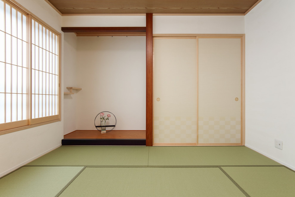 Cette image montre une salle de séjour asiatique de taille moyenne avec un mur blanc, un sol de tatami et un sol vert.