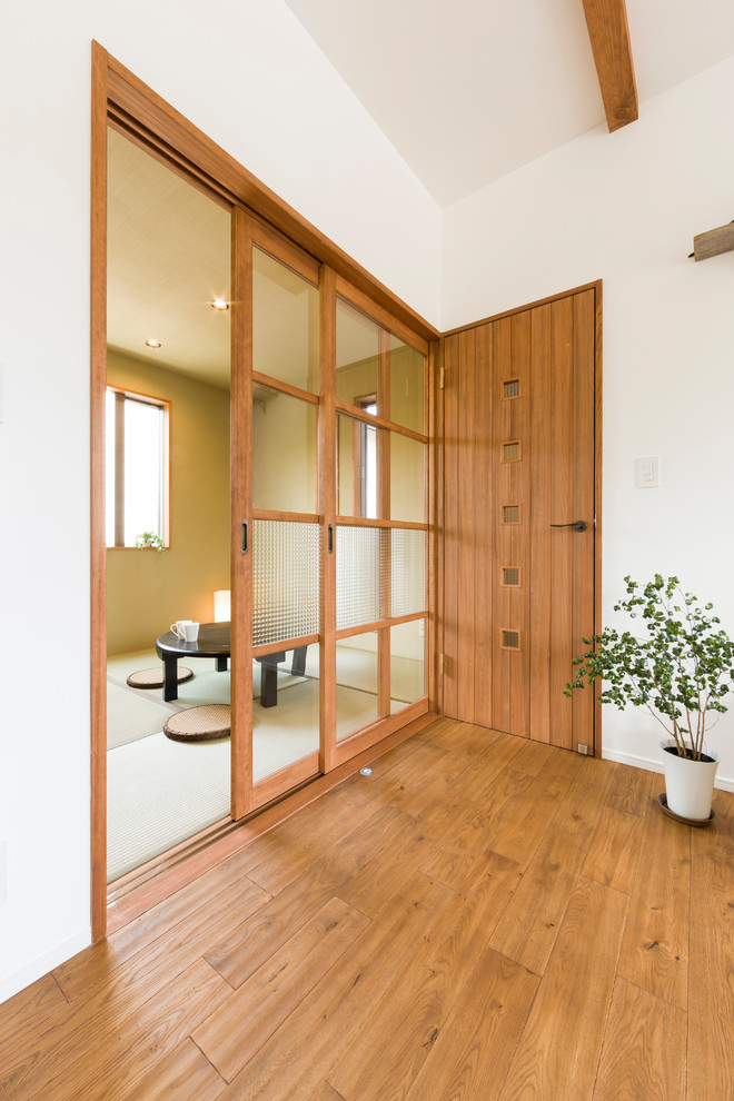 Aménagement d'une salle de séjour campagne fermée avec un mur beige, un sol de tatami et un sol vert.