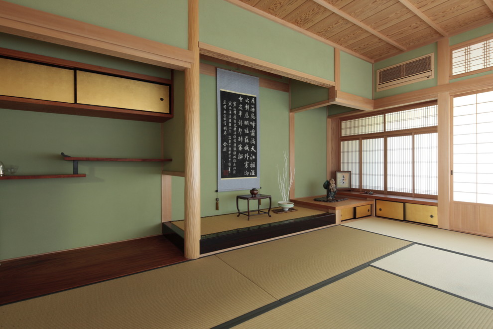 Idée de décoration pour une salle de séjour asiatique avec un mur vert et un sol de tatami.