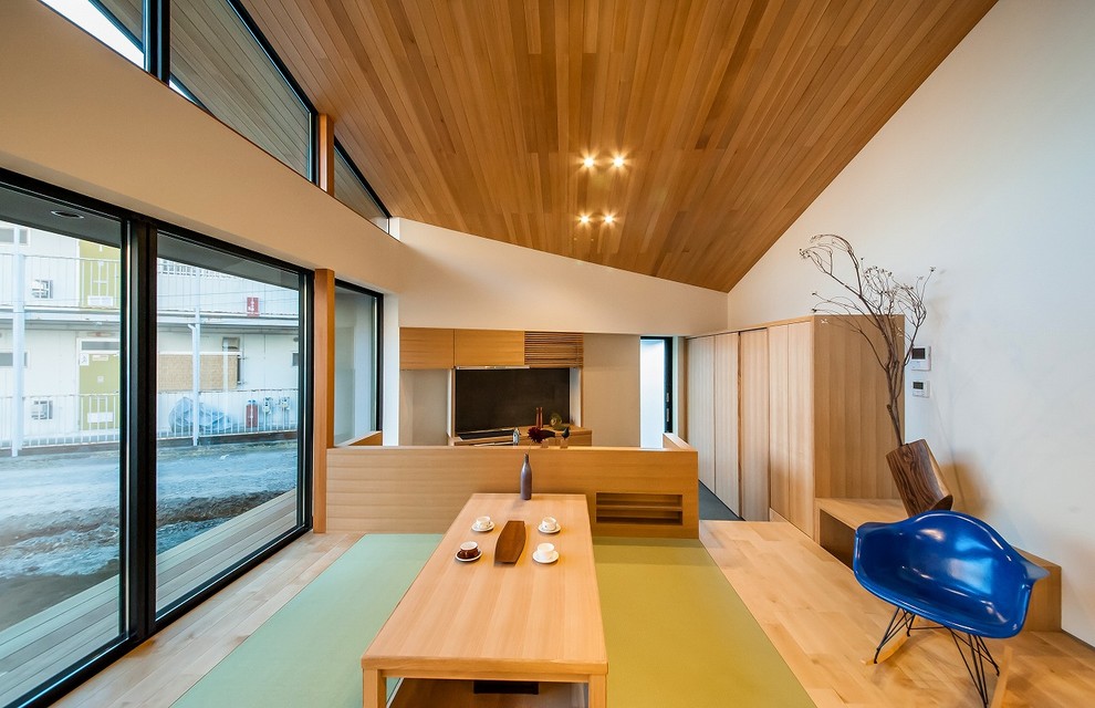 Foto de sala de estar abierta asiática de tamaño medio con paredes blancas, suelo de madera clara y suelo beige