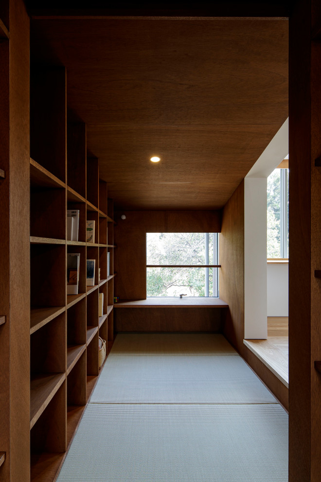 Idée de décoration pour une salle de séjour minimaliste de taille moyenne avec une bibliothèque ou un coin lecture, un mur marron, un sol de tatami, aucun téléviseur et un sol vert.