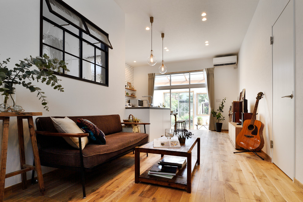 Imagen de sala de estar abierta nórdica con paredes blancas, suelo de madera en tonos medios y suelo marrón