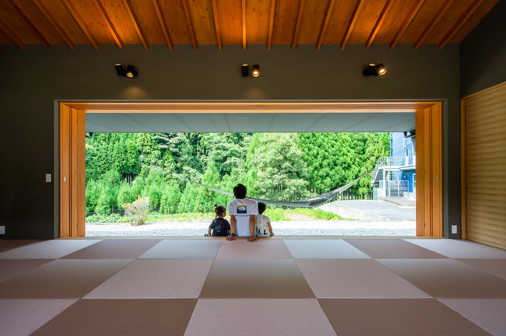 Imagen de sala de estar minimalista sin televisor con paredes verdes, tatami y suelo gris