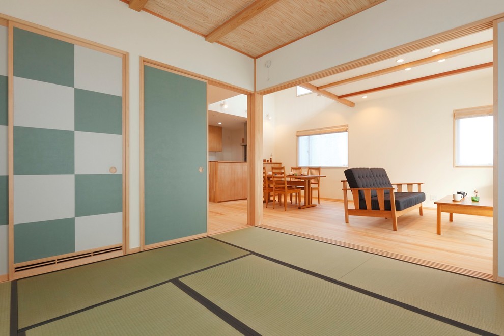 Idée de décoration pour une salle de séjour asiatique ouverte avec un mur blanc et un sol de tatami.
