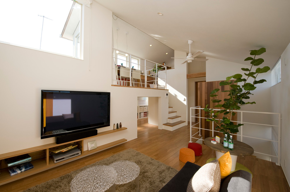 Ispirazione per un soggiorno stile marinaro con pareti bianche, pavimento in legno massello medio, TV autoportante e pavimento marrone
