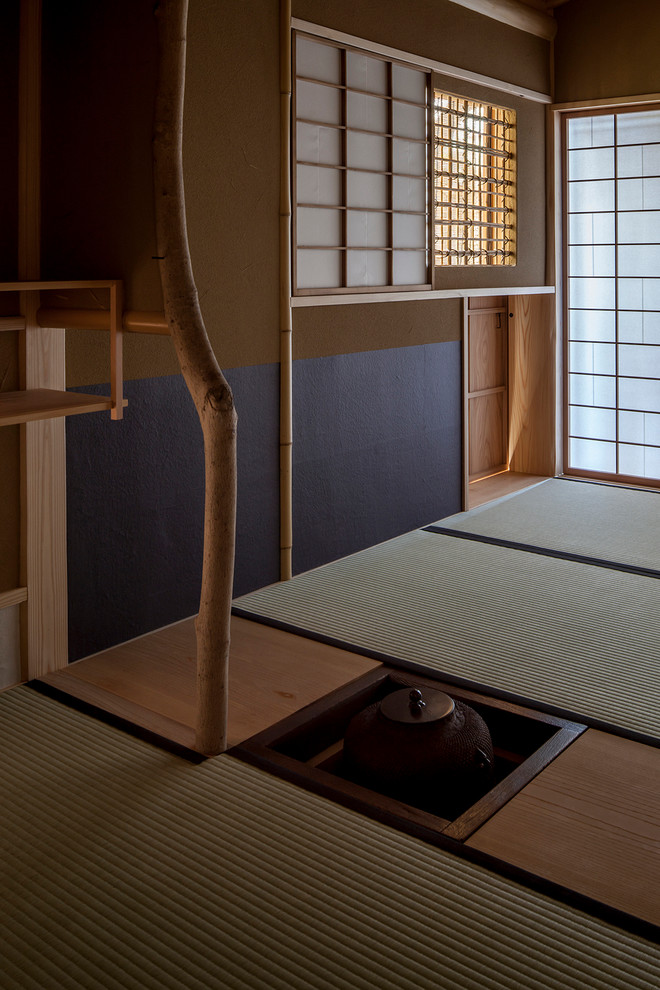 Example of a zen tatami floor family room design in Tokyo with black walls and no tv