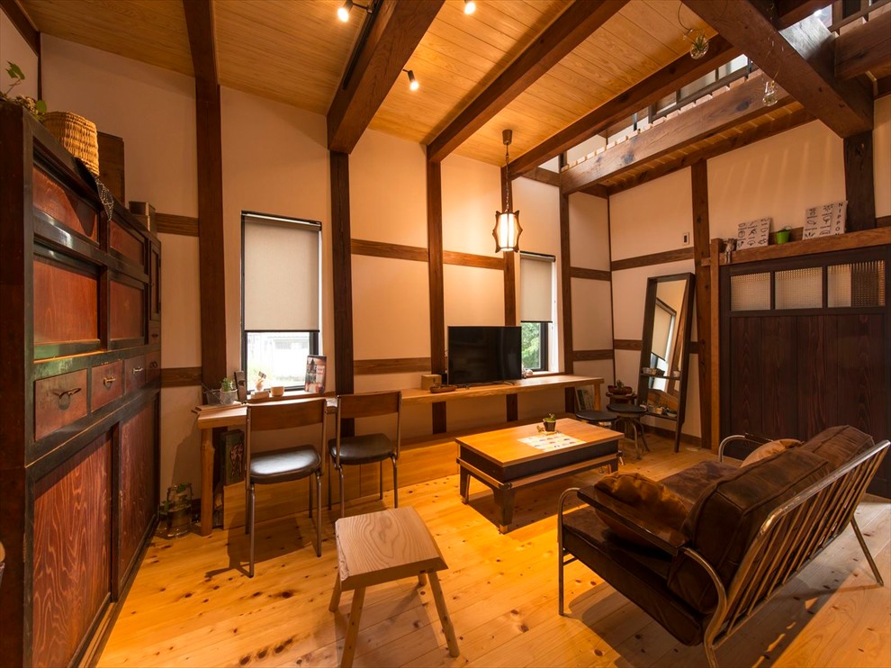 Ejemplo de sala de estar asiática con paredes blancas, suelo de madera en tonos medios y televisor independiente