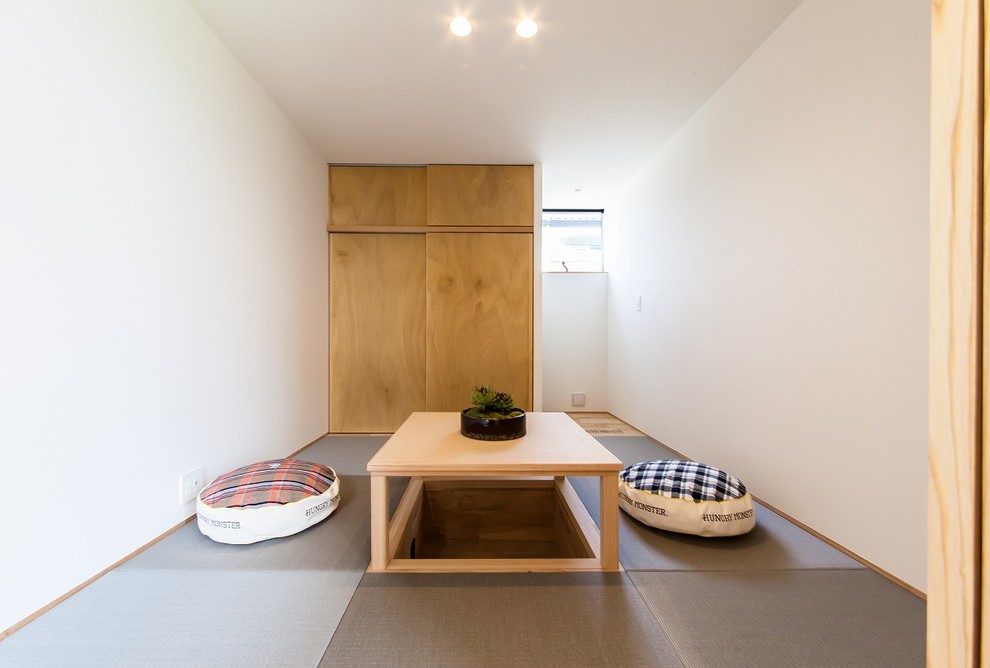 Ejemplo de sala de estar asiática pequeña con paredes blancas, tatami y suelo gris
