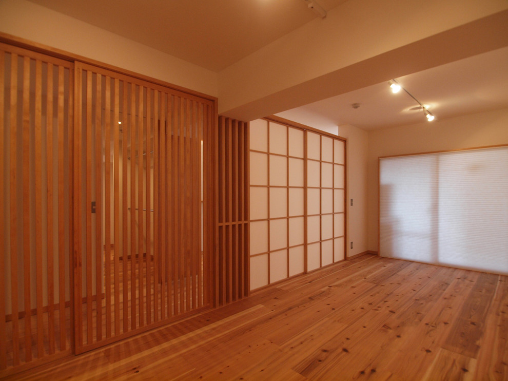 Foto på ett minimalistiskt allrum, med vita väggar, mellanmörkt trägolv och brunt golv