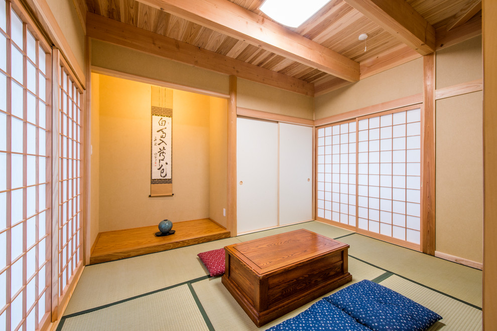 Imagen de sala de estar cerrada asiática pequeña con paredes beige, tatami y suelo verde