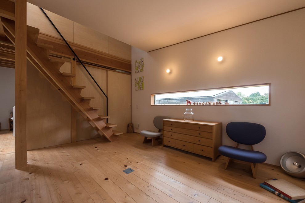 Kleines, Fernseherloses, Offenes Skandinavisches Wohnzimmer mit weißer Wandfarbe, hellem Holzboden, Kaminofen und beigem Boden in Sonstige