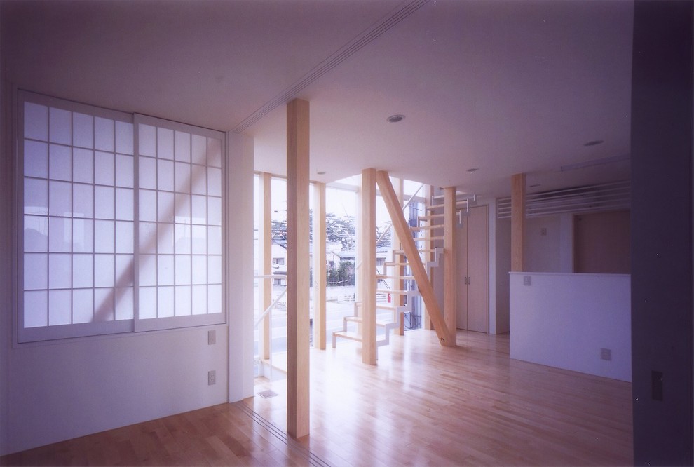 Diseño de sala de estar abierta moderna con paredes blancas y suelo de madera clara